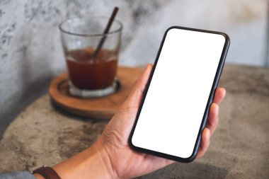 Boş beyaz masaüstü ekranlı cep telefonu tutan bir kadının görüntüsü