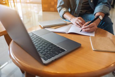 Masaya dizüstü bilgisayarı olan bir kadının yakın plan fotoğrafı.