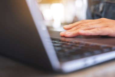 Masadaki dizüstü bilgisayarda çalışan ve dokunan bir kadının yakın plan görüntüsü.