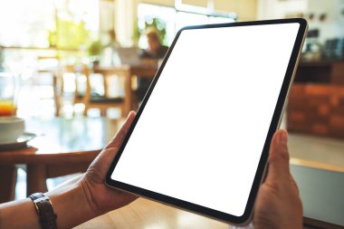 Boş beyaz masaüstü ekranlı dijital tableti tutan bir kadının görüntüsü