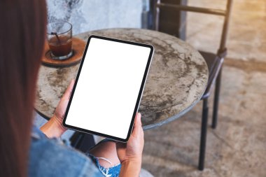 Boş beyaz masaüstü ekranlı dijital tableti tutan bir kadının görüntüsü
