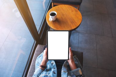 Boş beyaz masaüstü ekran ile dijital tablet tutan bir kadının en üst görünüm görüntüsü