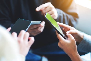 Birlikte cep telefonu kullanan ve arayan bir grup genç.