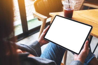 Boş beyaz masaüstü ekranlı dijital tableti tutan bir kadının görüntüsü