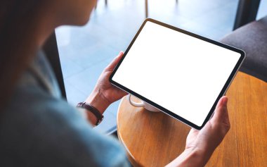 Boş beyaz masaüstü ekranlı dijital tableti tutan bir kadının görüntüsü