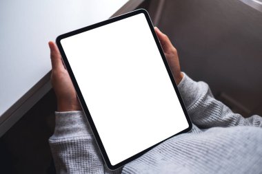 Boş beyaz masaüstü ekran ile dijital tablet tutan bir kadının en üst görünüm görüntüsü