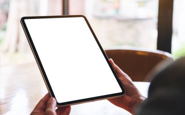 Boş beyaz masaüstü ekranlı dijital tableti tutan bir kadının görüntüsü