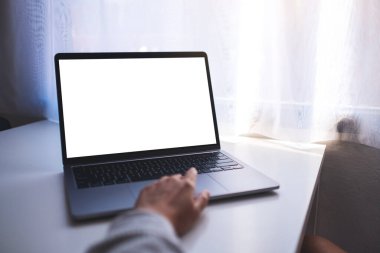 Bir iş kadınının masadaki boş beyaz masaüstü ekranı ile laptopa dokunuşunu ve dokunuşunu taklit et.