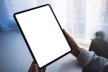 Boş beyaz masaüstü ekranlı dijital tableti tutan bir kadının görüntüsü