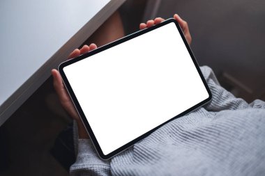 Boş beyaz masaüstü ekran ile dijital tablet tutan bir kadının en üst görünüm görüntüsü