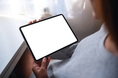 Boş beyaz masaüstü ekran ile dijital tablet tutan bir kadının en üst görünüm görüntüsü