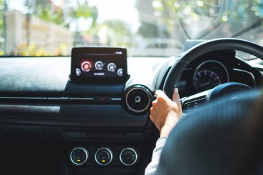 Bir kadının direksiyon tutarken yolda araba kullanırken ki görüntüsü.