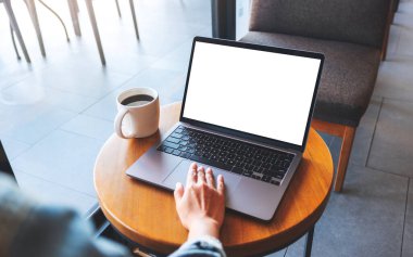 Kafede boş beyaz masaüstü ekranı olan bir kadının laptopa dokunuşunu ve dokunuşunu görüntüle