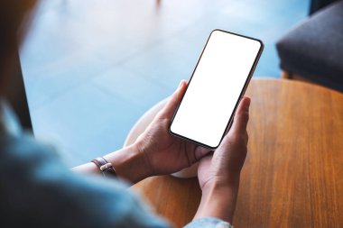 Boş beyaz masaüstü ekranlı cep telefonu tutan bir kadının görüntüsü