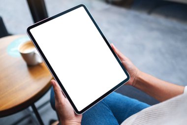 Boş beyaz masaüstü ekranlı dijital tableti tutan bir kadının görüntüsü