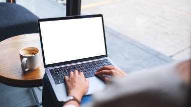 Laptop bilgisayar klavyesinde boş beyaz masaüstü ekran kullanan ve yazan bir kadının görüntüsü 