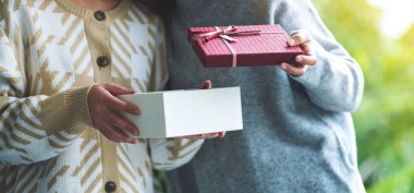 İki kadın birlikte bir hediye kutusu açıyor.