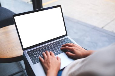 Laptop bilgisayar klavyesinde boş beyaz masaüstü ekran kullanan ve yazan bir kadının görüntüsü 