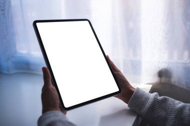Boş beyaz masaüstü ekranlı dijital tableti tutan bir kadının görüntüsü