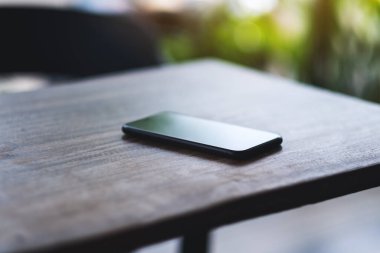 Ahşap masada bir cep telefonu. 