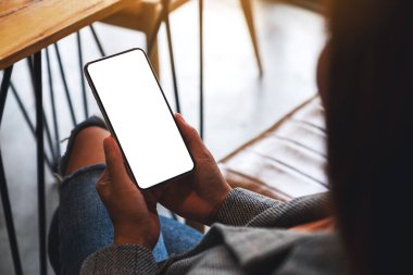 Boş beyaz masaüstü ekranlı cep telefonu tutan bir kadının görüntüsü