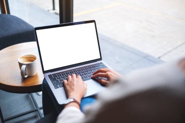 Laptop bilgisayar klavyesinde boş beyaz masaüstü ekran kullanan ve yazan bir kadının görüntüsü 