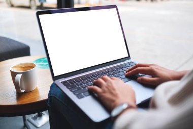 Laptop bilgisayar klavyesinde boş beyaz masaüstü ekran kullanan ve yazan bir kadının görüntüsü 