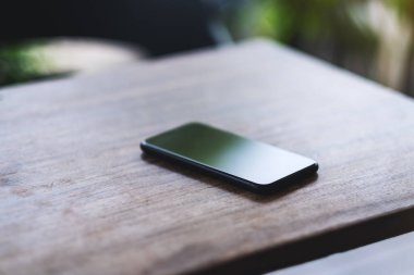 Ahşap masada bir cep telefonu. 