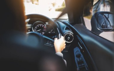 Bir kadının direksiyon tutarken yolda araba kullanırken ki görüntüsü.