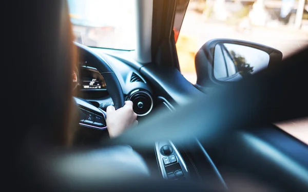 在道路上驾驶汽车时系上安全带的妇女手握方向盘的后视镜图像 — 图库照片
