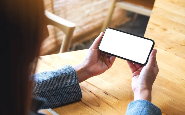Boş beyaz masaüstü ekranlı cep telefonu tutan bir kadının görüntüsü