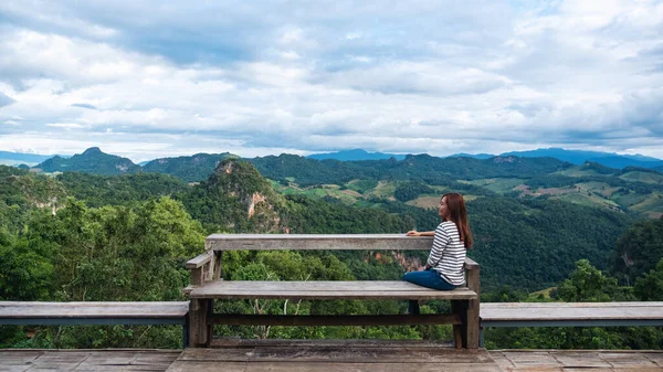 Oturan ve güzel bir dağ manzarasına bakan bir kadın gezginin portresi. 