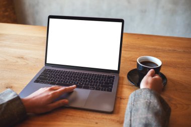 Kahve içerken bilgisayarın dokunmatik dokunmatik ekranını beyaz ekranla kullanan ve dokunan bir kadının görüntüsü 