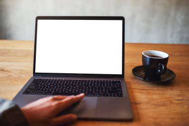 Masasında kahve fincanı olan ve boş beyaz masaüstü ekranı olan bir kadının laptopa dokunuşunu ve dokunuşunu görüntüle. 