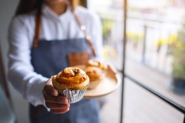 Bir garson kucağında bir parça kurabiye veriyor. 