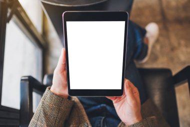 Boş beyaz masaüstü ekran ile siyah tablet bilgisayarını tutan bir kadının en üst görünüm görüntüsü 