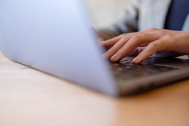 Masada dizüstü bilgisayarda çalışan ve daktilo kullanan bir kadının yakın plan resmi