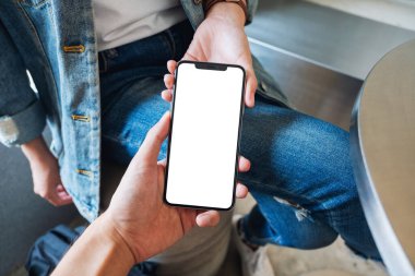 Boş siyah masaüstü ekranı olan beyaz cep telefonunu tutan ve gösteren bir kadının görüntüsü