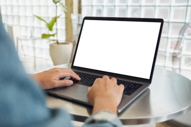 Boş beyaz masaüstü ekran kullanan ve dizüstü bilgisayarda yazan bir kadının görüntüsü 