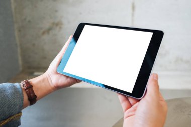 Siyah tablet taşıyan beyaz ekranlı bir kadının görüntüsü. 