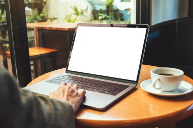 Masasında kahve fincanı olan ve boş beyaz masaüstü ekranı olan bir kadının laptopa dokunuşunu ve dokunuşunu görüntüle. 