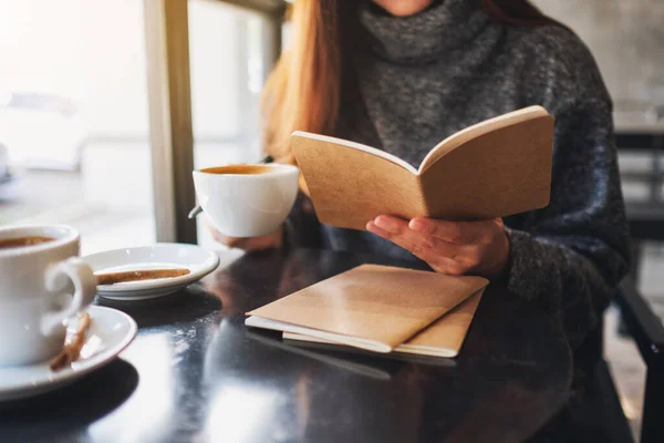 Närbild Kvinna Som Läser Bok Medan Hon Dricker Kaffe Caféet — Stockfoto