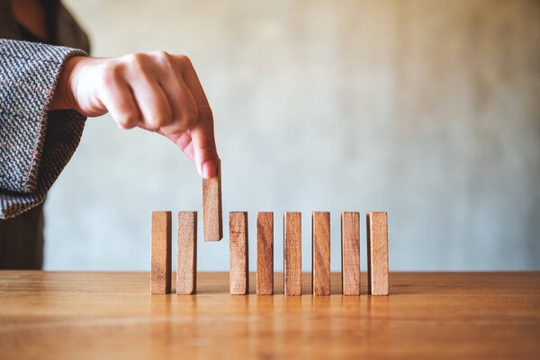 Closeup image of businessman putting wooden block in a row on the table for business concept