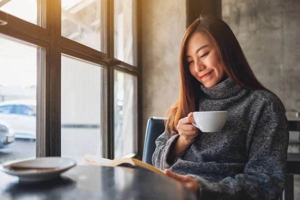 Sabahları kahve içerken kitap okuyan güzel bir kadının yakın plan görüntüsü.