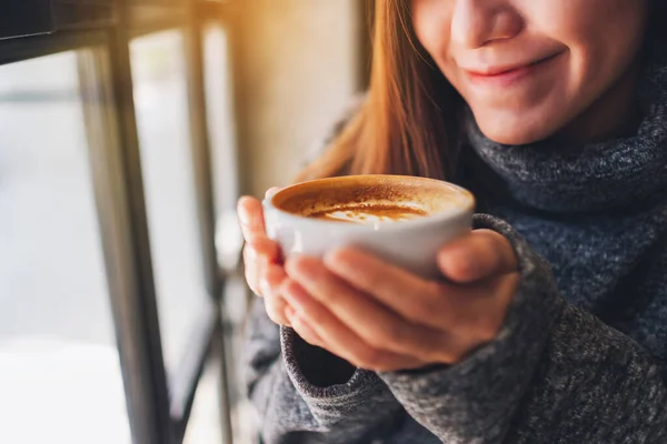 一个漂亮的亚洲女人拿着一杯热咖啡的照片 — 图库照片