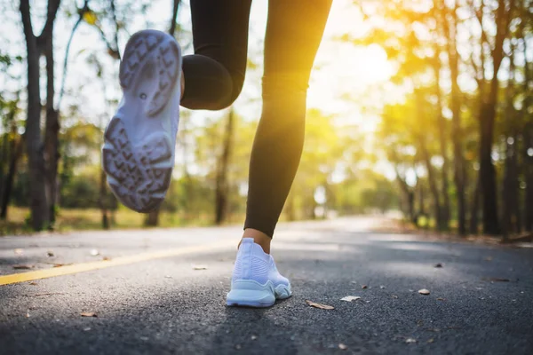 Sabah şehir parkında koşarken bir kadının bacaklarının yakın görüntüsü.