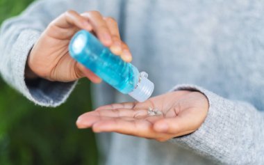 Sağlık ve Covid-19 konsepti için temiz ellere alkol jeli süren bir kadının yakın plan görüntüsü