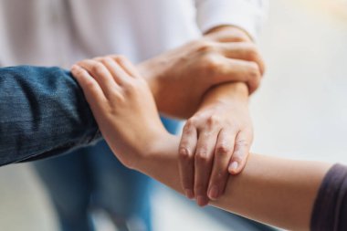 İnsanlar birlik ve takım çalışması konsepti için ellerini bir çemberin içine sokuyorlar.