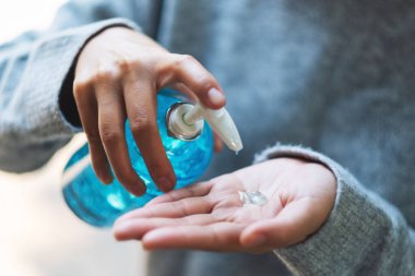 Sağlık ve Covid-19 veya 2020 virüs konsepti için alkol jeli dezenfektanı kullanan ve uygulayan bir kadının yakın plan görüntüsü
