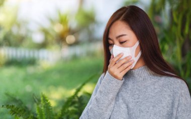 Sağlık ve Covid-19 veya 2020 virüs konsepti için koruyucu yüz maskesi takan Asyalı bir kadının yakın plan görüntüsü